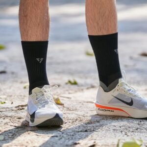 Close-up of running shoes and socks on a sunny outdoor path, featuring casual sportswear style.